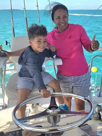 A mother and son giving a thumbs up at the helm of the Magic