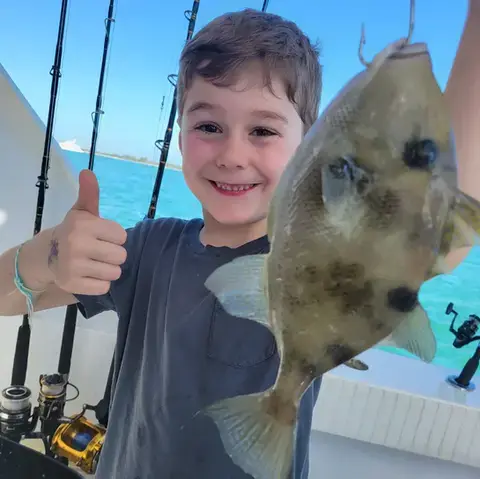 Angler holding a black grouper caught on a Key West reef trip