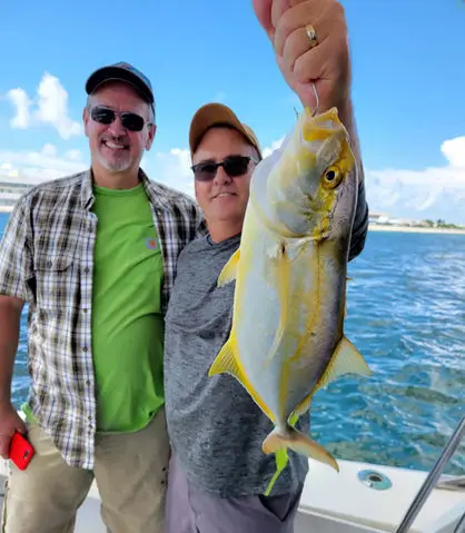 A couple holding a reef grouper aboard the Magic