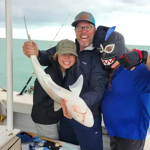 Two anglers holding a yellow jack caught offshore of Key West