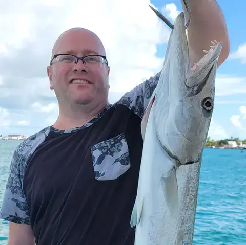 Family holding a small shark caught on a Key West shark fishing trip
