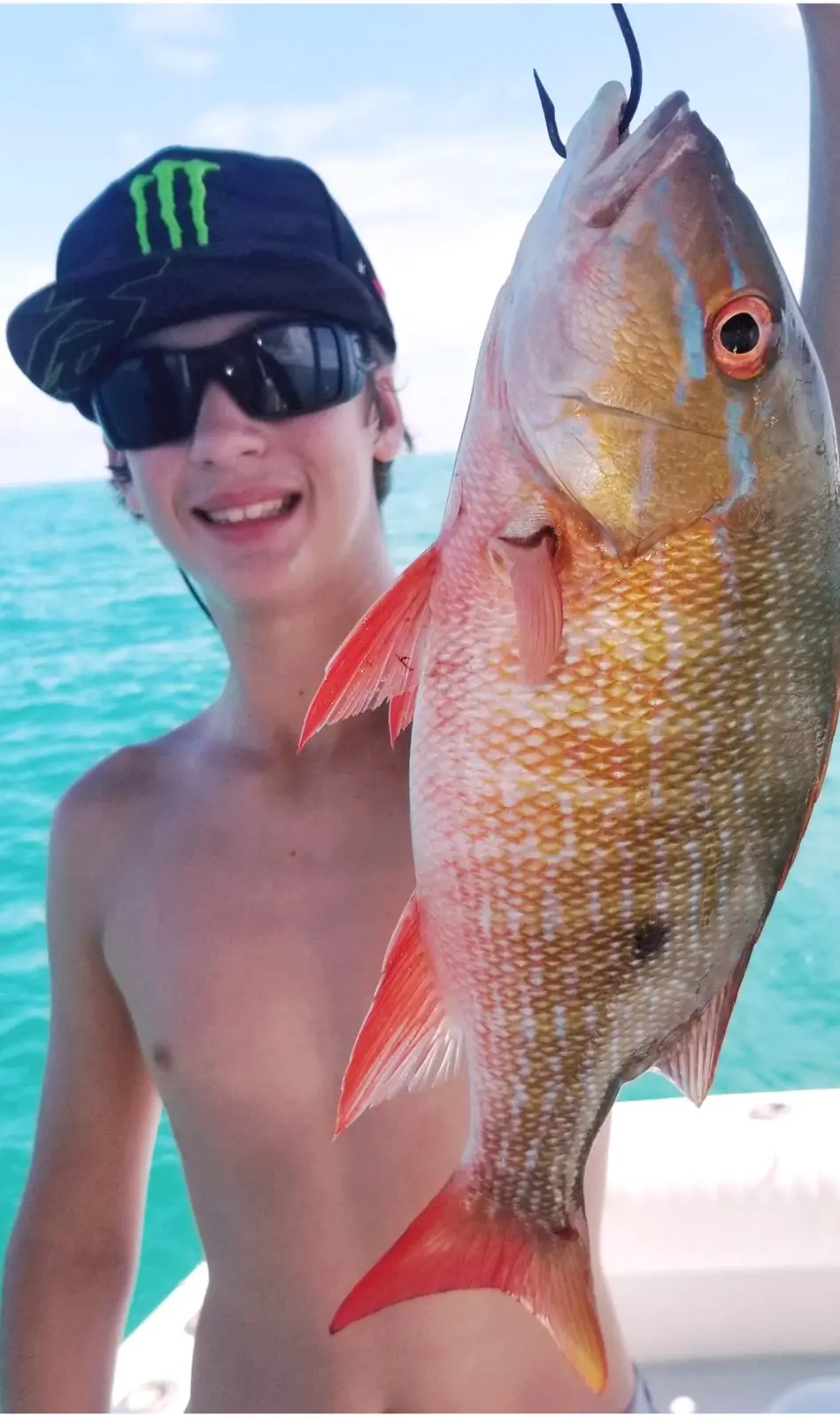 A young angler holding a mutton snapper