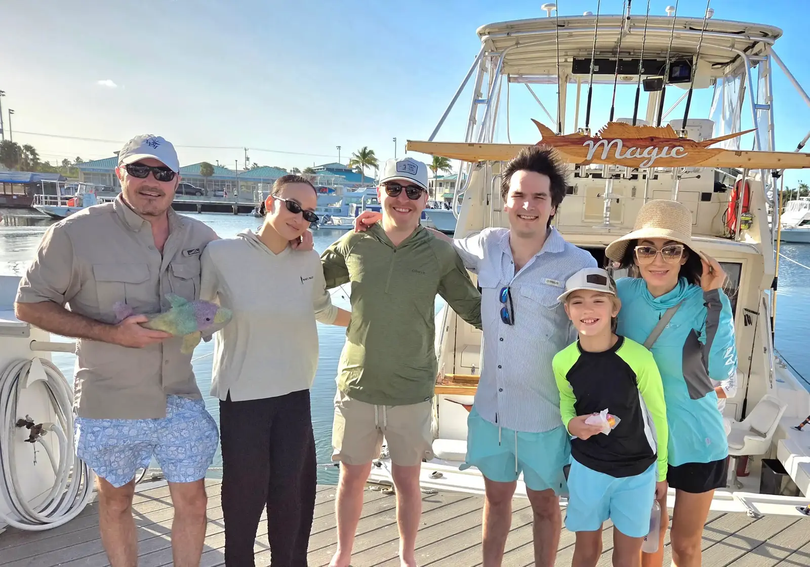 A group of six friends posing on the dock next to the Magic