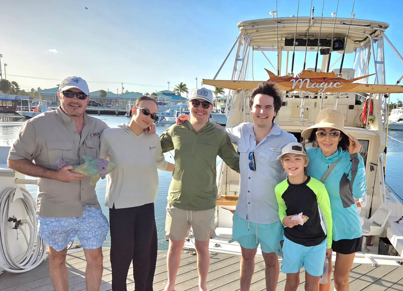 Anglers reeling in a shark from the deck of the Magic